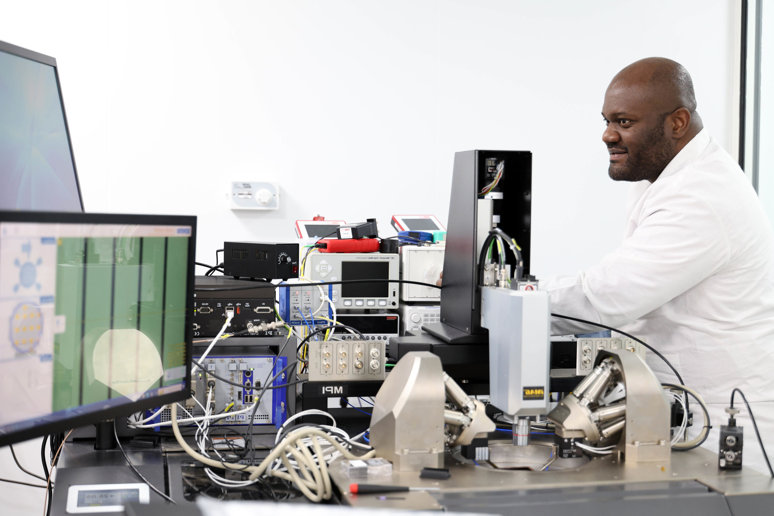 A scientist in a lab coat operates advanced scientific equipment at a laboratory workbench. - CSA Catapult